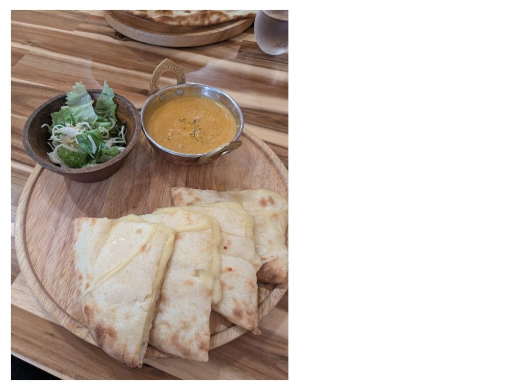 厚みのある贅沢なチーズナンの断面 (Side view of thick and cheesy naan at CIRCLE)