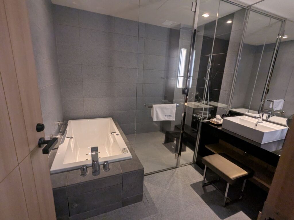 箱根離宮と同タイプの、開放感あふれるガラス張りのバスルームとジャグジー / Open-concept glass-walled bathroom with a relaxing jacuzzi, similar to Hakone Rikyu.