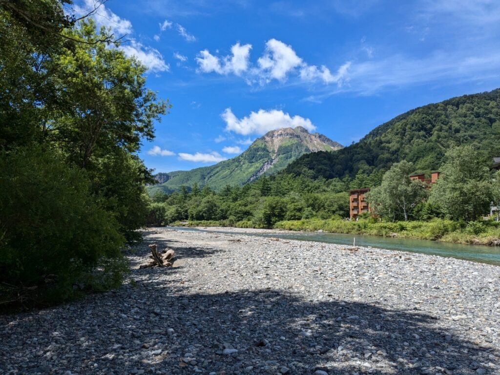 梓川の川辺に降りて触れる、氷水のように冷たくて透明なエメラルドグリーンの水面 / Touching the crystal-clear, emerald green water of the Azusa River, which is as cold as ice water.