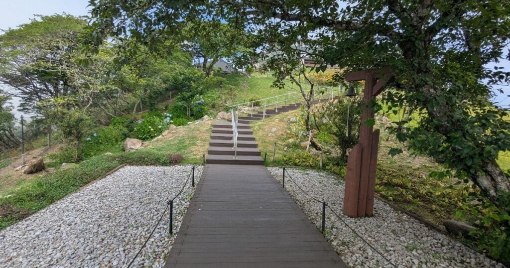 木々に囲まれた静かな散策路の先にあるハート型展望スポット (Peaceful tree-lined path leading to the heart-shaped observation point)
