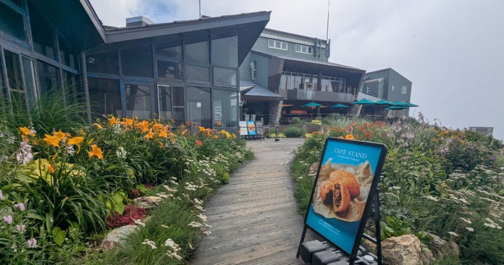 色鮮やかな花々に囲まれたびわ湖テラスのカフェへ続くアプローチ通路 (Path surrounded by colorful flowers leading to Biwako Terrace Cafe)
