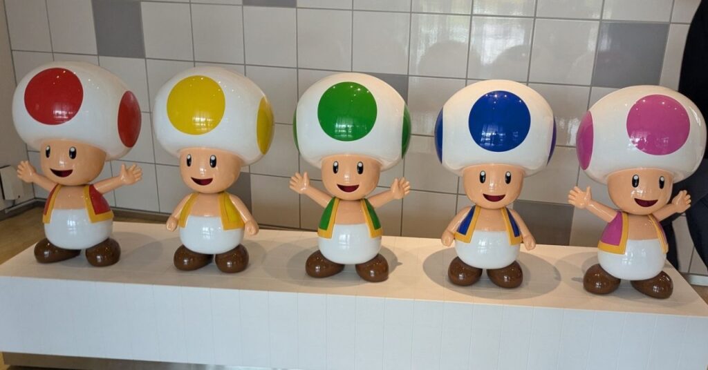 ニンテンドーミュージアムに展示されている色とりどりのキノピオたちのフィギュア (Colorful Toad figures displayed at Nintendo Museum in Kyoto)
